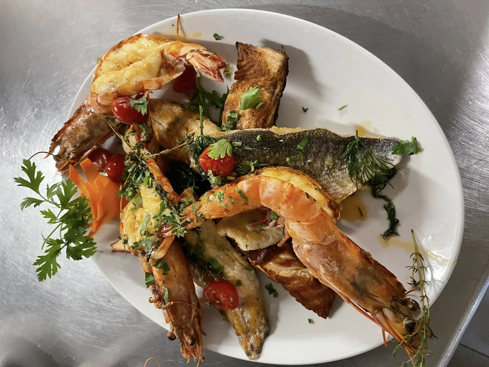 Gegrillte Garnelen und Fisch mit Gemüse auf einem Teller